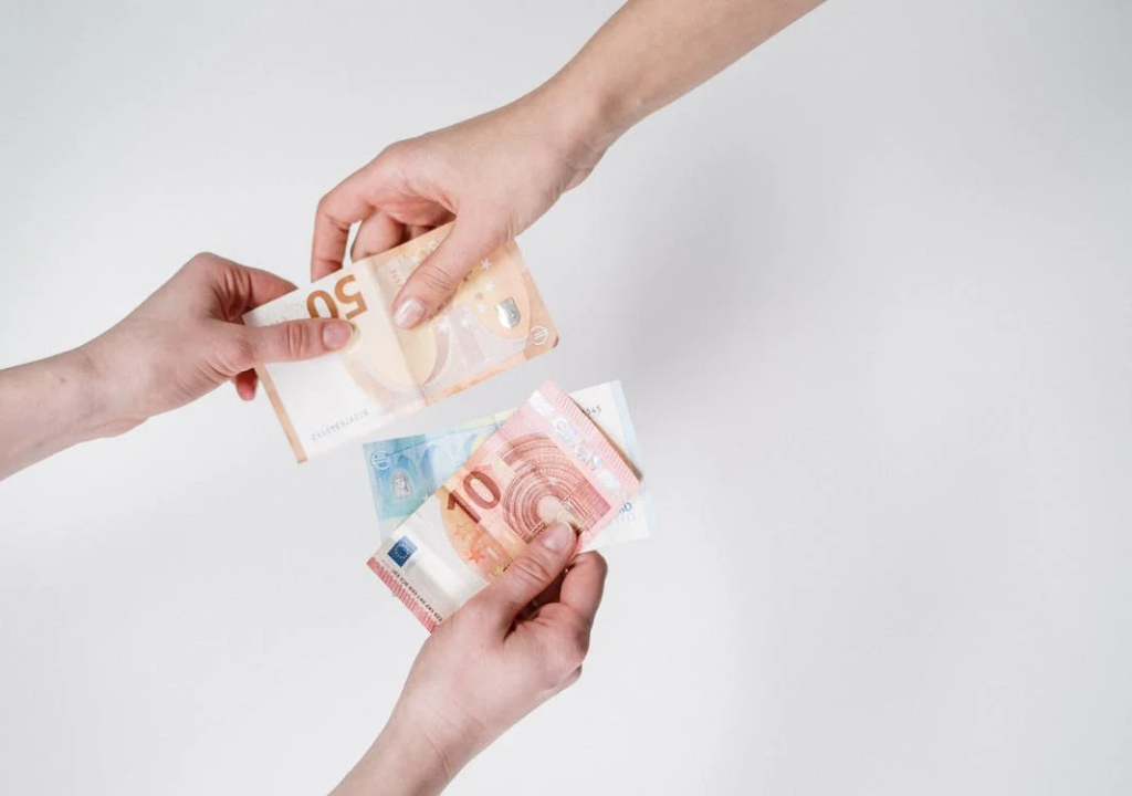 Den Preis für qualitativ hochwertigen Nachhilfeunterricht verstehen: Ein umfassender Leitfaden 2 Das Bild zeigt zwei Hände, die Euro-Banknoten austauschen, mit einem einfachen, hellen Hintergrund. Die Banknoten sind 50- und 10-Euro-Scheine. Diese Darstellung könnte in Diskussionen über Transaktionen, Währung oder das Konzept der Zahlung relevant sein.